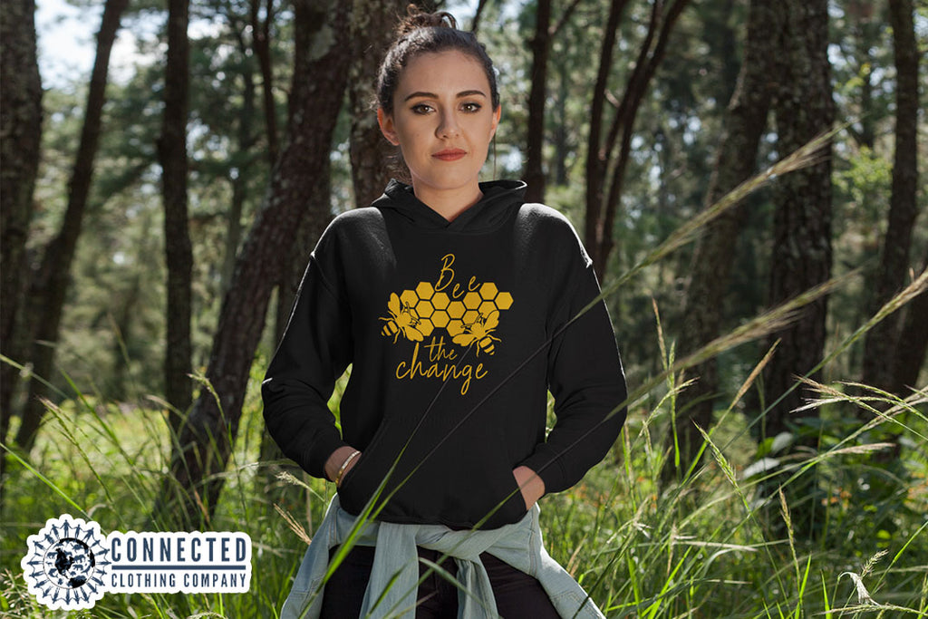 Model Wearing Black Bee The Change Hoodie In A Field - Ethically & Sustainably Made - sweetsherriloudesigns - 10% donated to The Honeybee Conservancy