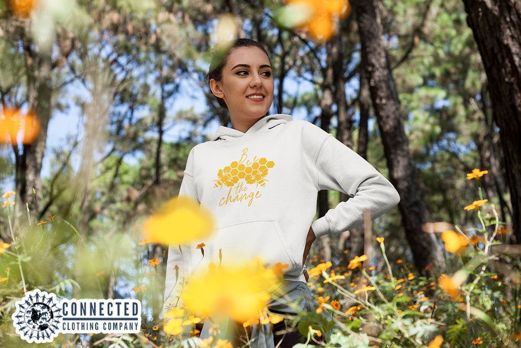Model Wearing White Bee The Change Hoodie In A Field - Ethically & Sustainably Made - sweetsherriloudesigns - 10% donated to The Honeybee Conservancy