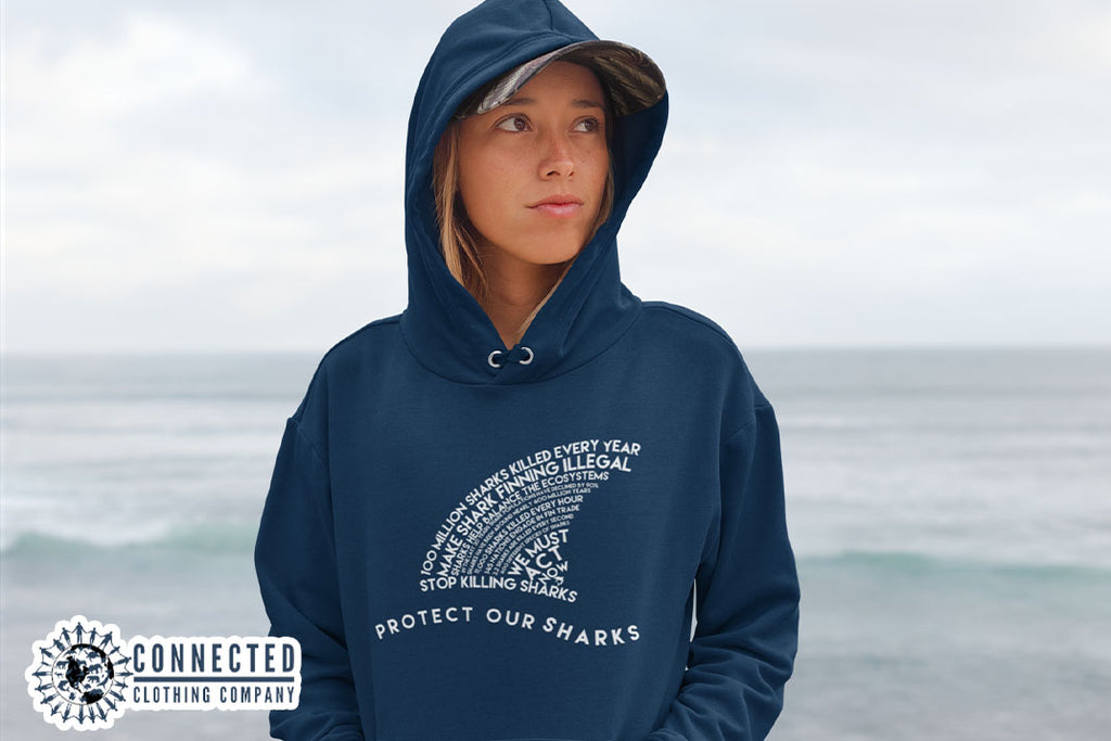 woman on the beach wearing navy blue Protect Our Sharks Unisex Hoodie - sweetsherriloudesigns - Ethically and Sustainably Made - 10% donated to Oceana shark conservation